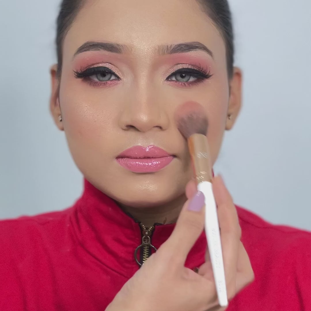 artist using tapered powder brush on model face