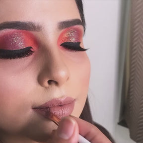 makeup artist using lipstick brush on model lips