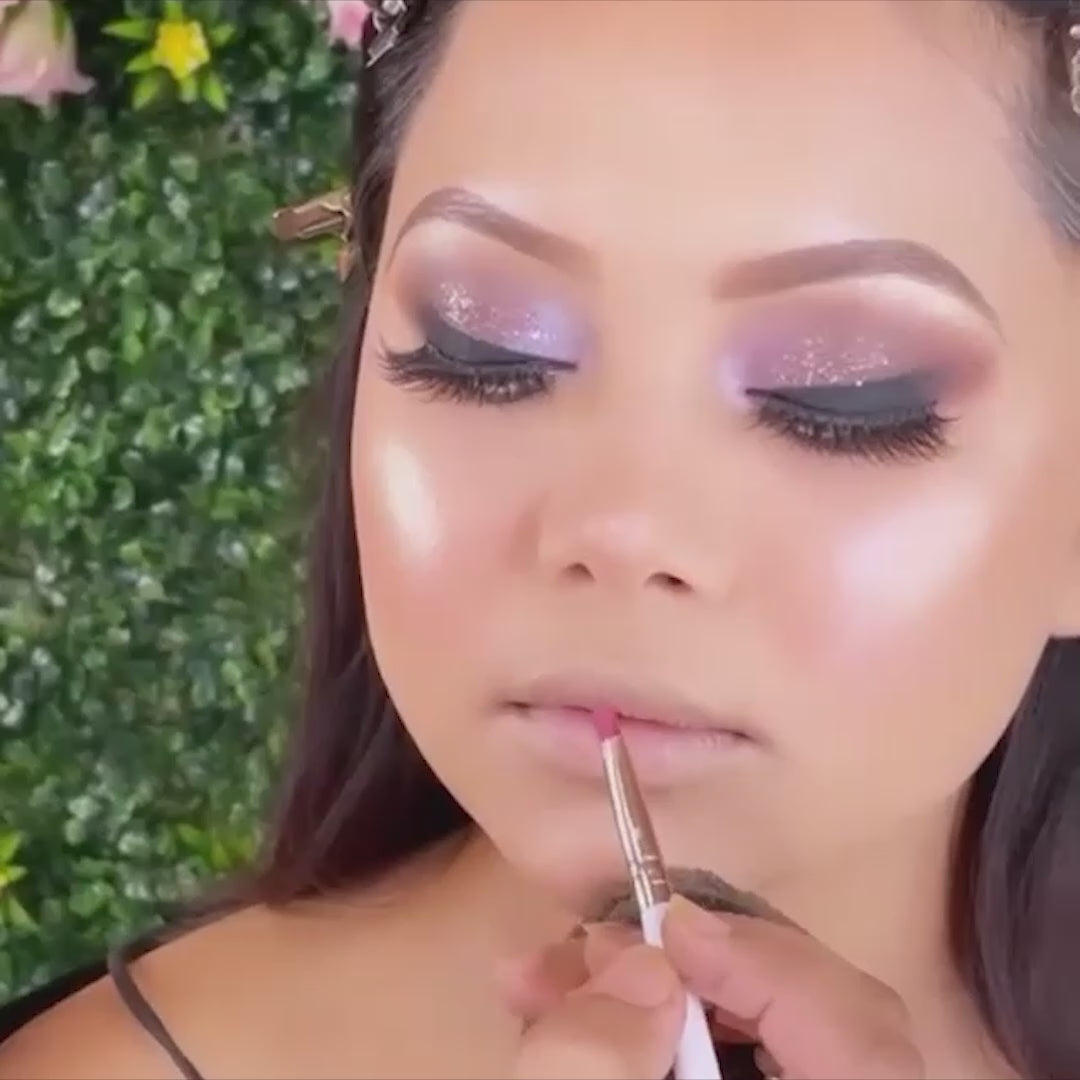 artist using lipstick brush on model lips