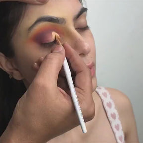 artist using cut crease brush on model eyelids