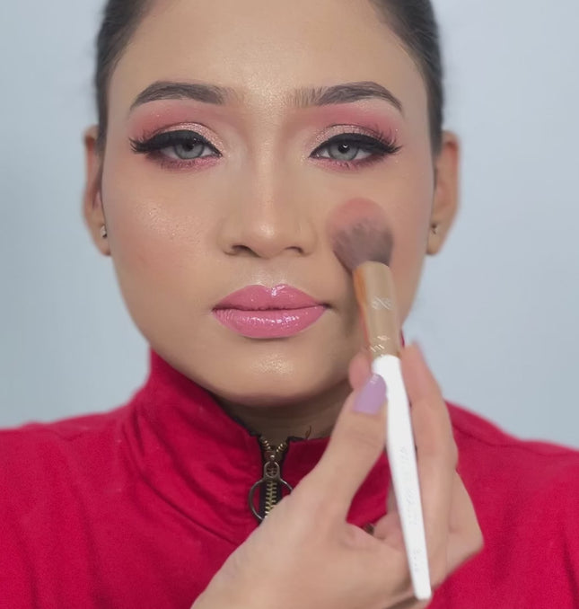 artist using tapered powder brush on model face