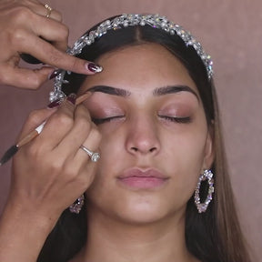 artist using dual ended brow brush on model eyebrows